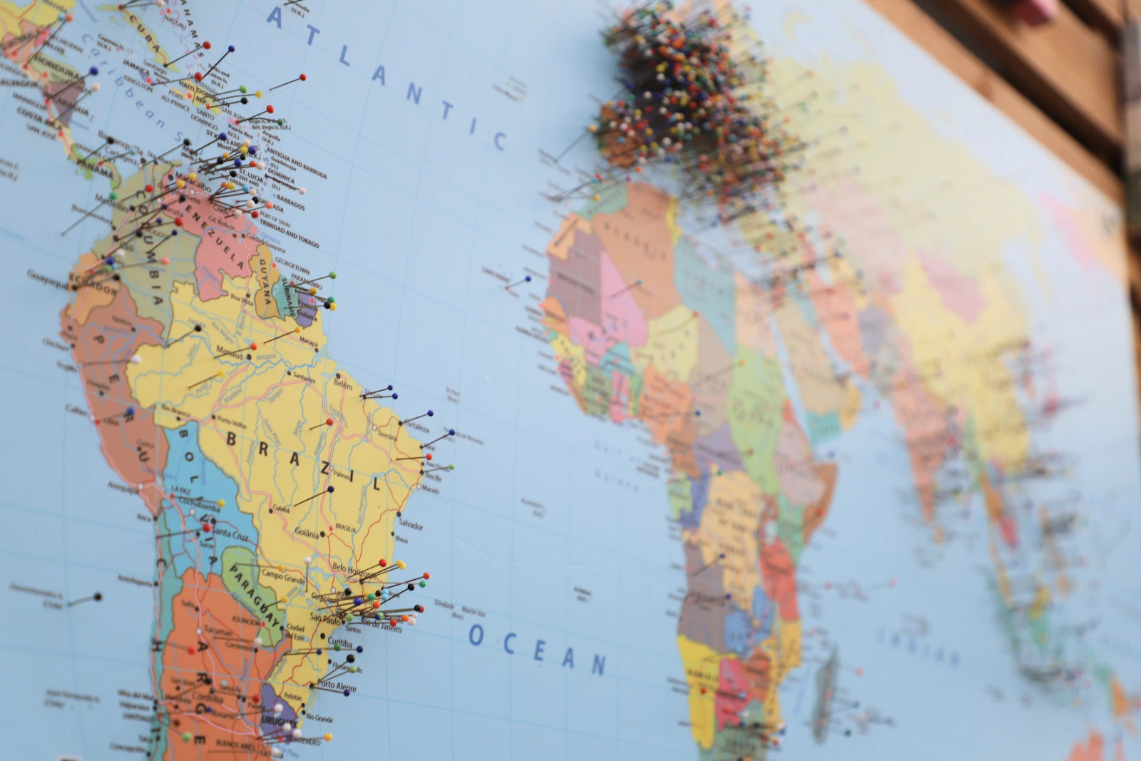 Mapa-múndi com alfinetes marcando destinos na América do Sul e África