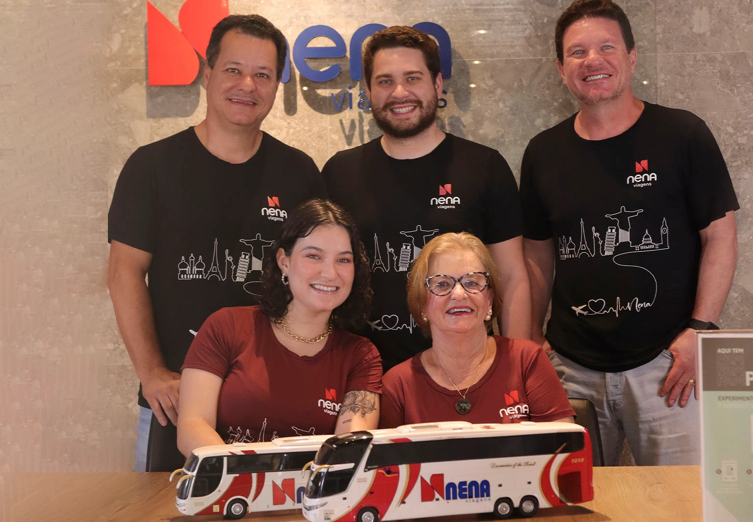 Família Nena Viagens com miniaturas dos ônibus da frota, na agência em Franca
